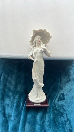 A Giuseppe Armani porcelain figurine of a lady with a parasol.