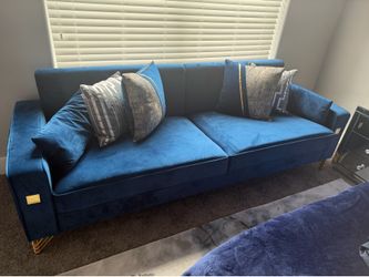 Blue velvet couch with decorative pillows