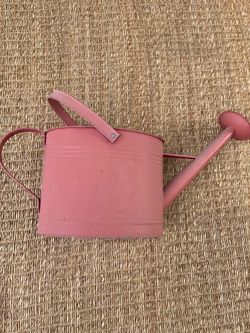 Faded red watering can