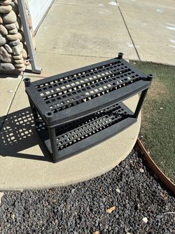 Durable black plastic storage shelf with two tiers. 3’ long, about 17” deep and 18” between the shelves
