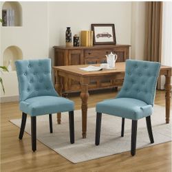 Set of 2 tufted upholstered dining chairs—fabric side chairs featuring nailhead trim on the back, a pull ring, and solid wood legs; light blue.