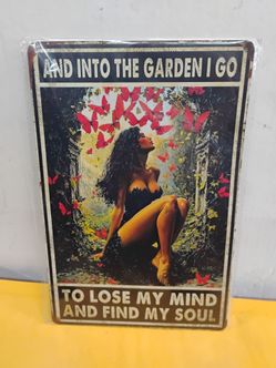 Decorative metal tin sign featuring a woman surrounded by red butterflies and foliage, with the phrase "And into the garden I go to lose my mind and f