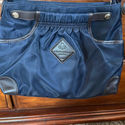 This is a navy blue nylon and leather shoulder bag, possibly from  POURCHET PARIS 1903