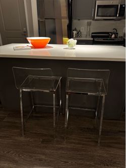 A pair of acrylic counter height stools from cb2