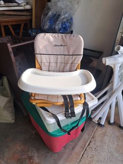 Antique Eddie Bauer wooden space-saver high chair with a plaid cushion.