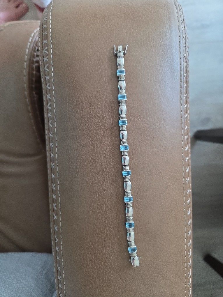 9 inch silver bracelet with blue topaz.