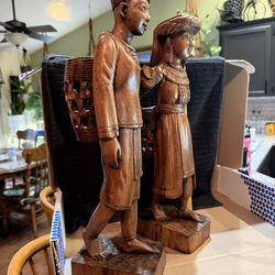 Vintage, hand-carved Asian wooden figurines representing a tribal man and woman