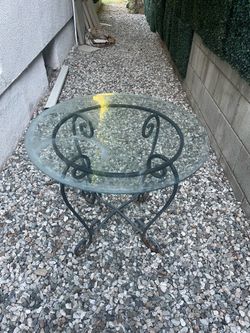 Wrought iron glass top outdoor/indoor table. Good cond. as is pick up deliver.