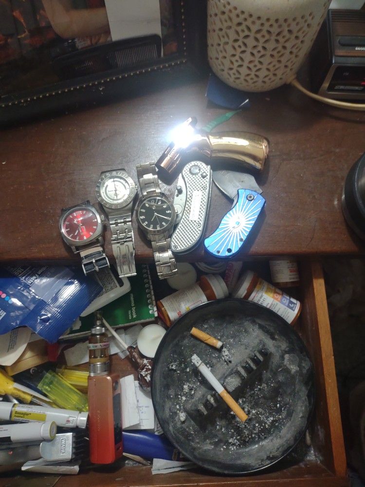 A Mixture Of Wrist Watches Small Pocket Knives And A Butane Lighter