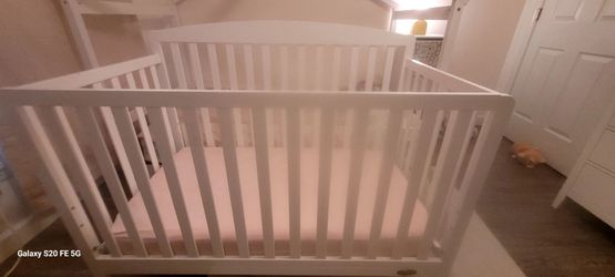 White baby crib with mattress