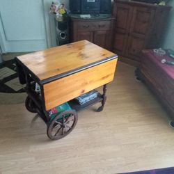 Old Serving cart Great Shape Has Pull Out tray also Storage Tray For Silverware Or accessories. Original wood spoked Wheels and Fold up Leafs.  