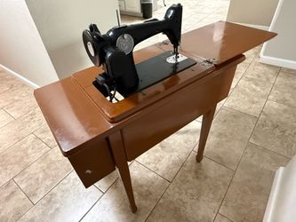 Vintage Singer sewing machine in a drop-leaf sewing cabinet