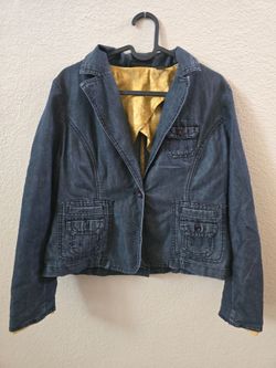 Structured denim blazer by Apostrophe. Dark blue exterior with a golden inner lining. Notched lapel and single-button closure. Button-flap pockets and