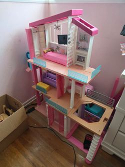 Barbie Dream House Camper Trailer and box of Barbie dolls.