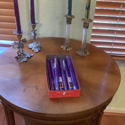 two sets of ornate candle holders with extra candles 