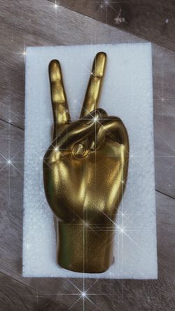 Golden hand sculpture - peace sign
