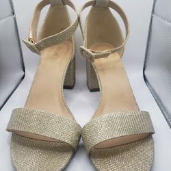 Size 8. a pair of gold glitter open-toe ankle strap sandals under the brand name Blu Sol.