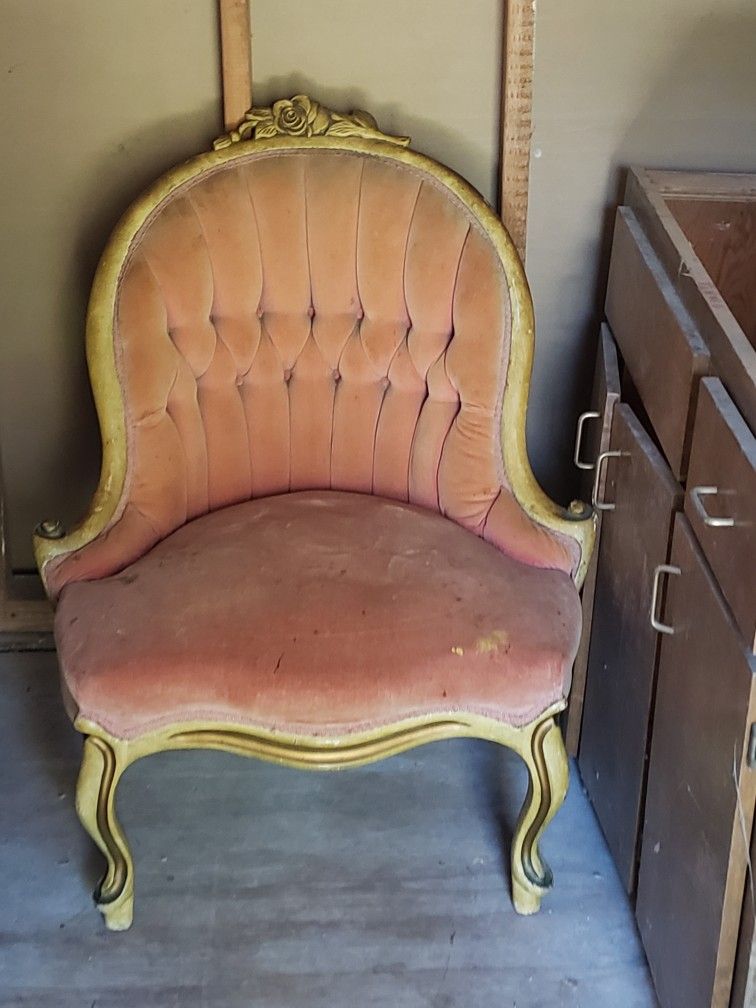antique Victorian Rococo Revival parlor chair with a tufted pink velvet seat and a carved wooden frame. 