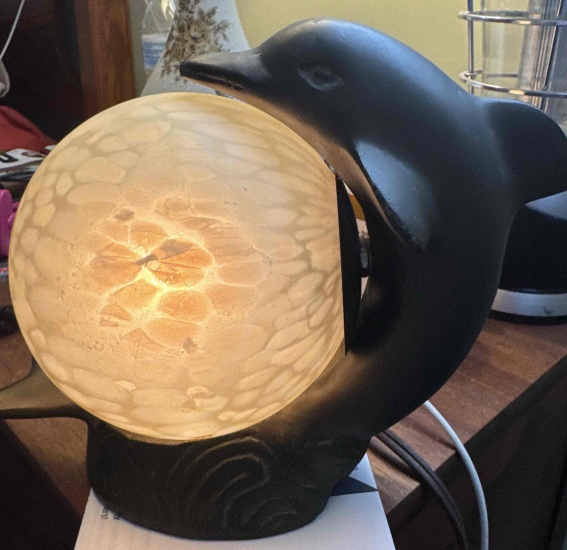 This is a vintage Art Deco Metal dolphin lamp with a spherical glass shade.