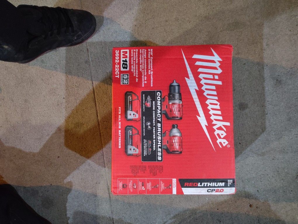 2 Milwaukee Tools Drill And Impact Driver Two Batteries And A Charger And A Bag