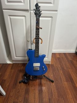 First Act ME5008 electric guitar. This model features a distinct single-cutaway design and a bright blue glossy finish