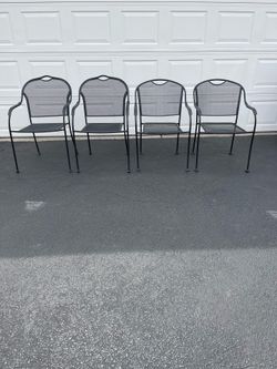 Four Black Wrought Iron Stackable Arm Chairs