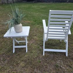 Folding chairs and a white wooden table. The table measures 20' x 20'. The chair is 39" high x 32" wide