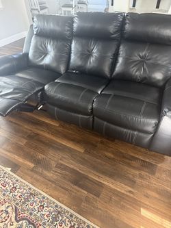 Black Faux Leather Reclining sofa, love seat, and recliner.