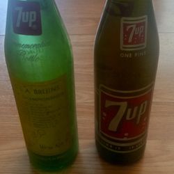 Two 7Up Bottles One Is Full Of Seven Up Another One Just Has A Lid To It