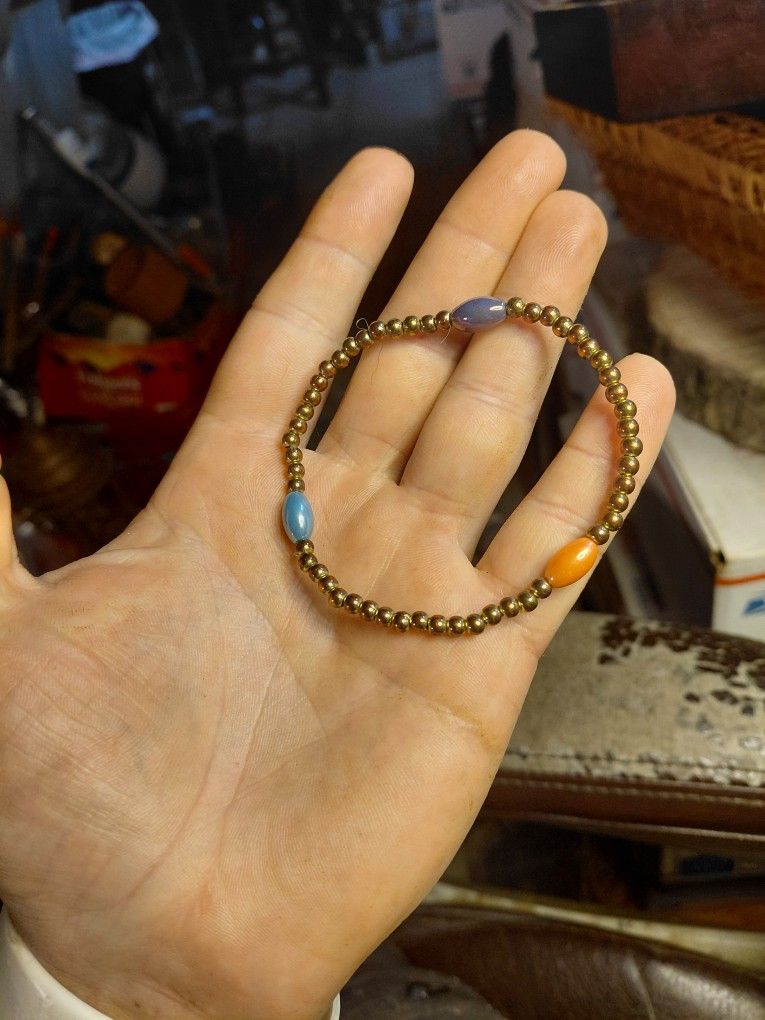 beaded stretch bracelet featuring small, metallic brown beads and larger, oval-shaped