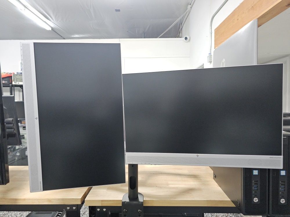 Dual HP LED 1080P WIDESCREEN MONITOR WITH POWER CORDS ON A SINGLE STAND.