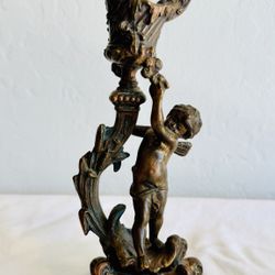 antique Rococo-style figural bronze candlestick featuring a cherub