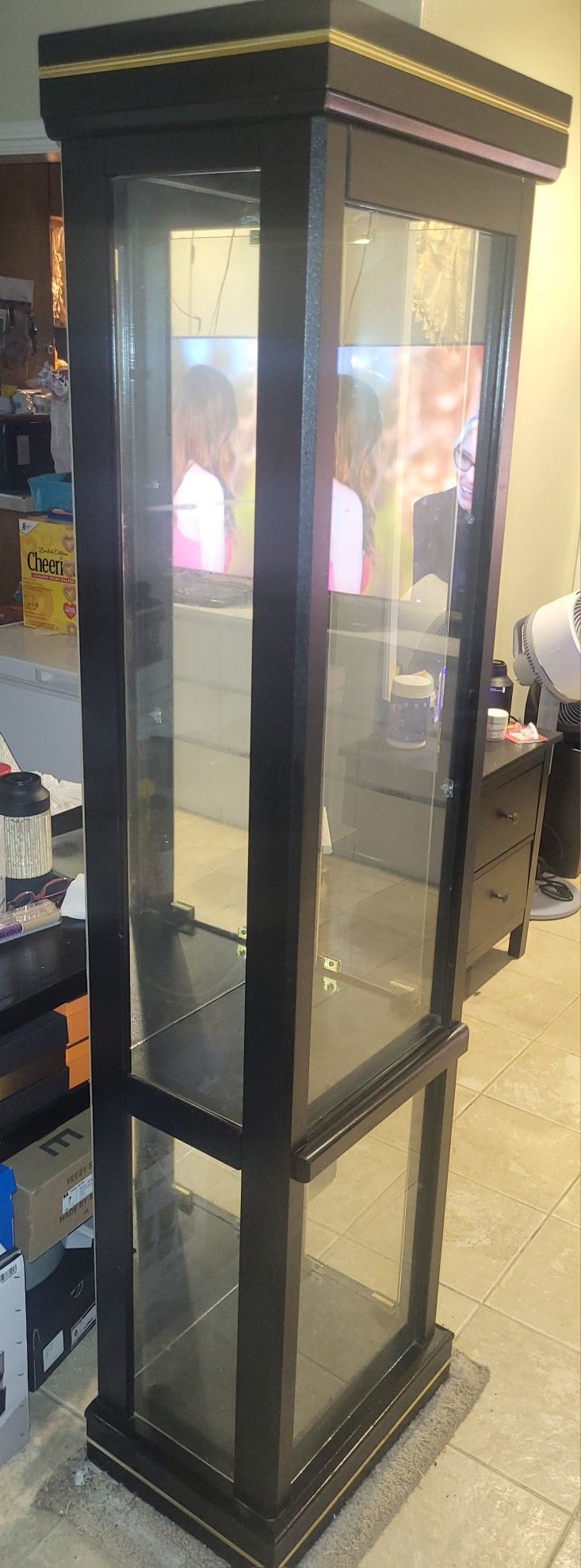 This is a black wooden and glass curio display cabinet. 