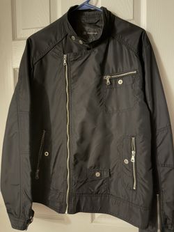 chaqueta que se muestra es de la marca INC International Concepts (I.N.C.), talla M (Medium), y está hecha de 100% Nylon en el exterior (Shell) y 100%