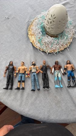 Assorted WWE figures (Roman Reigns, John Cena, Brodie Lee, The Rock, Kofi Kingston, AJ Styles)