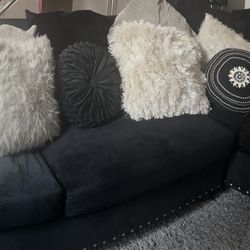 Black Sectional With Pillows, Area Rug And Coffee Table