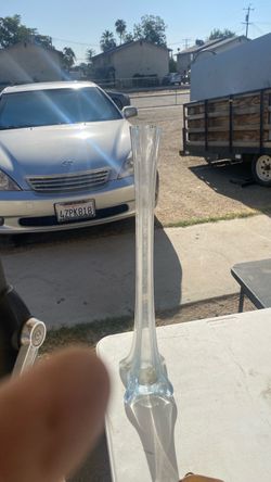tall, slender Eiffel Tower clear glass vase. Characterized by its narrow, fluted column body and a wide, four-pronged flared base resembling the struc