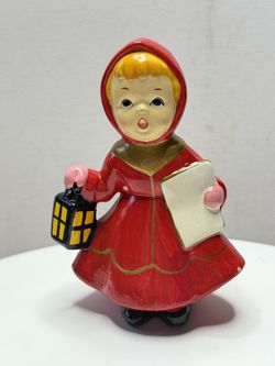 Vintage figurine of a caroling girl in a red dress