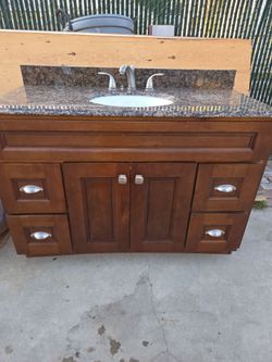 Gabinete  para ban̈o con zink de 48" 4 cajones con cubierta y back splash  de granito con llave