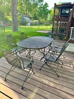 Large wrought iron patio set, table and 6 bouncy chairs with 2 person glider, delivery available for extra cost