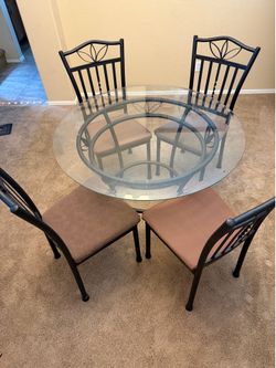 Glass table four padded chairs kitchen cafe