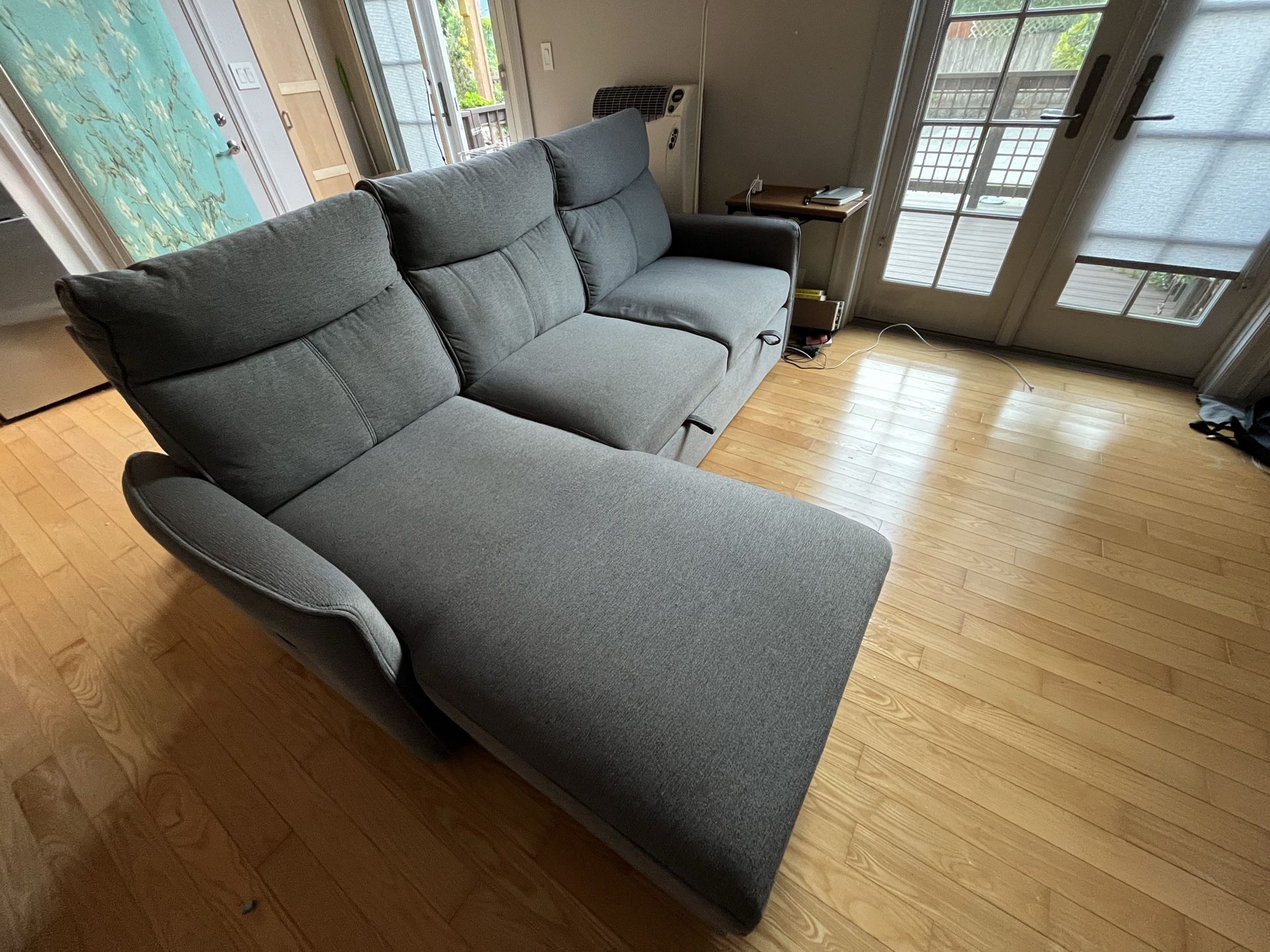 Gray sleeper fabric L-shaped sofa with a chaise lounge and storage