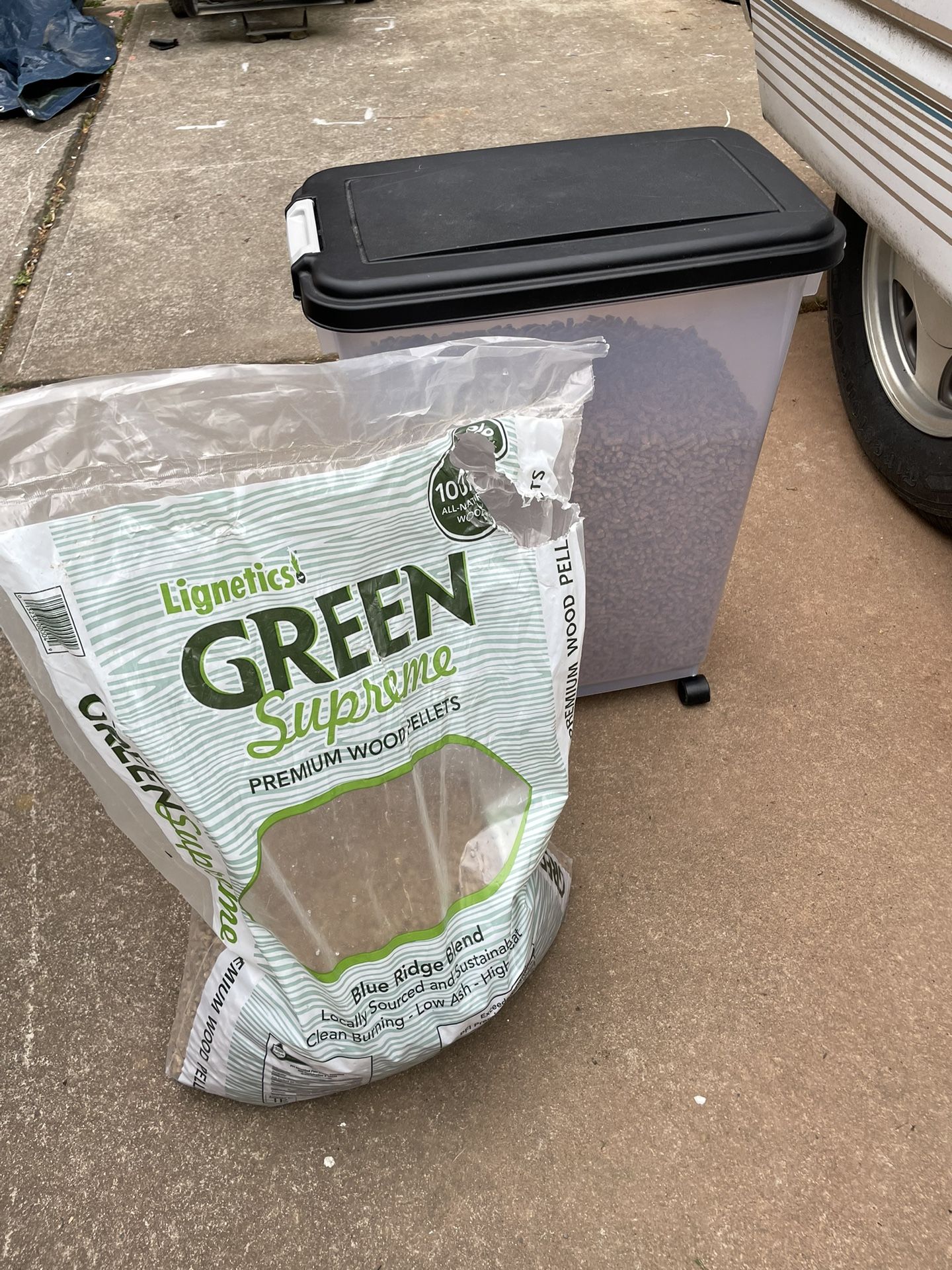 Green supreme premium wood pellets in reusable plastic storage container