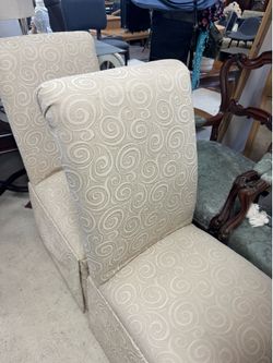Set of 8 beige jacquard slipcovered parson dining chairs with floor-length skirts and swirl patterns