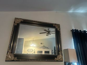 Extremely large black and gold ornate mirror.
