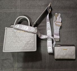 Betsey Johnson grey embossed skull mini satchel set features a signature skull-patterned strap and a matching heart-quilted wallet.