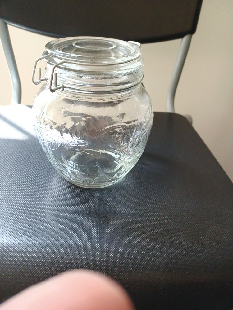 A BALL MASON JAR WITH LEAFS AND FRUITS