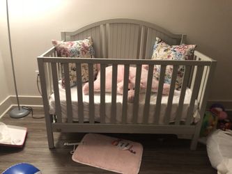 Convertible gray baby bed with mattress
