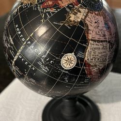 modern decorative desk globe, likely manufactured within the last 15 years. While it has a "vintage" aesthetic due to the black oceans and tan contine