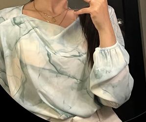 Calvin Klein long-sleeve blouse with a light sea-green and white marble-style
